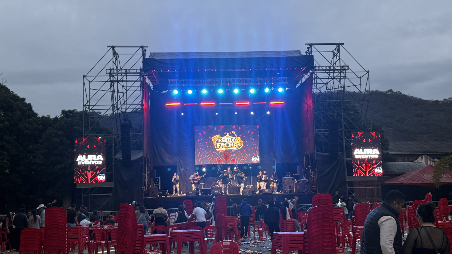 Escenario iluminado de noche con banda en vivo